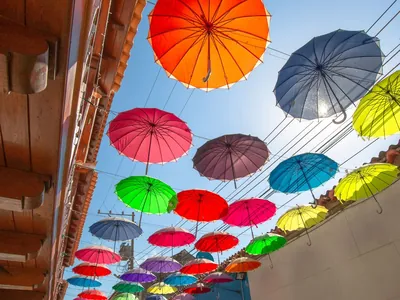 Rua decorada com guarda-sóis coloridos em Cartagena